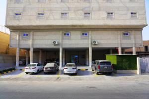 un edificio con coches estacionados en un estacionamiento en Wahaj Al Mesak Units, en Dammam