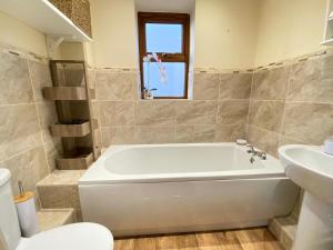 Birdwell For Contractors : حمام مع حوض أبيض ومغسلة