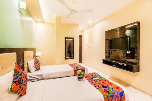 a living room with a bed and a tv at FabHotel Atlas Plaza Andheri East in Mumbai