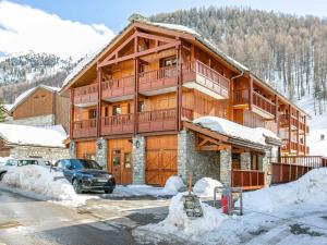 a large wooden house with a car parked in the snow at Appartement Val-d'Isère, 3 pièces, 5 personnes - FR-1-694-216 in Val-d'Isère
