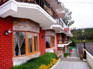 a red brick building with a pathway in front of it at Vista Peak View Ooty in Ooty