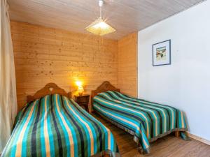 two beds in a room with wooden walls at Charmant 3 pièces avec balcon, Wifi, acceptant animaux, au centre de Val-d'Isère - FR-1-694-252 in Val dʼIsère