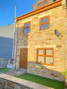 a stone house with a wooden door on the side of it at Birdwell For Contractors 