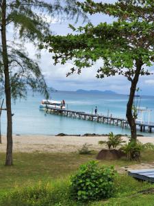 a pier on the beach with people walking on it at S Beach Resort in Ko Kood