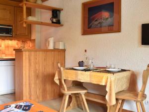 a kitchen with a wooden table and two chairs at Appartement Méribel, 1 pièce, 4 personnes - FR-1-180-10 in Méribel