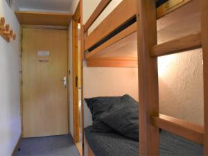 a bunk bed in a small room with a door at Appartement Méribel, 1 pièce, 4 personnes - FR-1-180-9 in Méribel