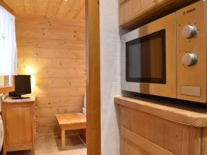 a living room with a television on a wooden wall at Appartement Méribel, 1 pièce, 2 personnes - FR-1-180-5 in Méribel