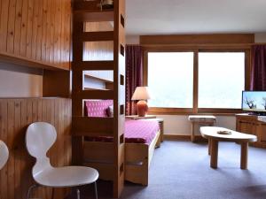 een slaapkamer met een stapelbed en een bureau en een bed bij Appartement Méribel, 1 pièce, 3 personnes - FR-1-180-21 in Méribel