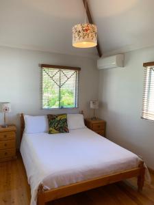 a bedroom with a white bed and two windows at Fremantle Accommodation Villas in Fremantle
