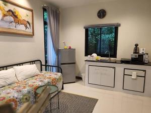 a living room with a bed and a kitchen at Snapper House in Khao Lak