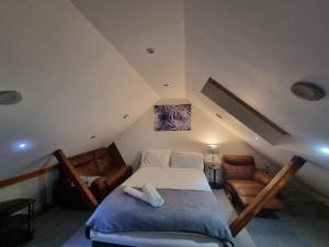 a attic bedroom with a bed and a couch at Sheri's Home away in Hither Green