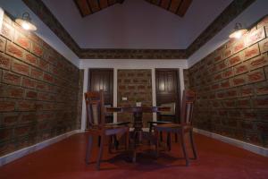 una mesa y sillas en una habitación con paredes de ladrillo en Ekantha Ala en Murinjupuzha