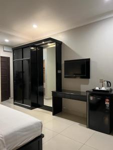 a hotel room with a bed and a television at Aneeda Inn in Pantai Cenang