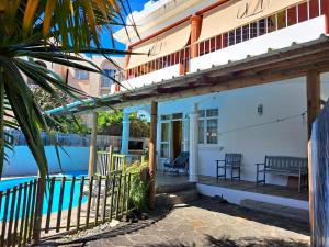 a house with a porch and a swimming pool at 3 bedrooms apartement at Pamplemousses 800 m away from the beach with private pool enclosed garden and wifi in Pamplemousses Village