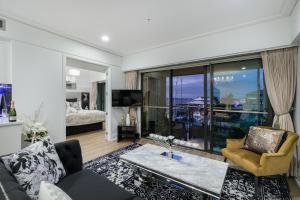 a living room with a couch and a table at Extravagant Escape in Auckland