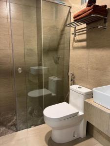 a bathroom with a toilet and a glass shower at Aneeda Inn in Pantai Cenang