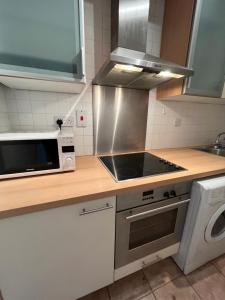 a kitchen with a stove top oven next to a microwave at The D3 Self Catering in Dublin