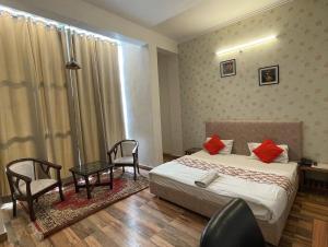 a bedroom with a bed and a table and chairs at Hotel Arrow 19 in Bareilly