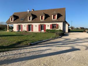 una casa con tetto di gamberi su una strada sterrata di Belle maison spacieuse avec grand jardin a Rongères