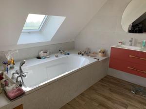 een groot wit bad in een badkamer met een raam bij Belle maison spacieuse avec grand jardin 