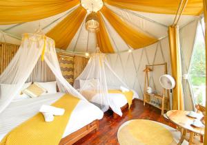 Nay Bungalow Dalat في دالات: غرفة نوم بسريرين في خيمة