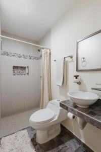 uma casa de banho com um WC branco e um lavatório. em El depa de Acuario em Cancún