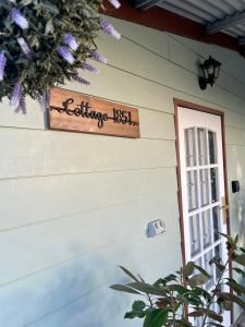 a sign on the side of a house with a window at • Cottage 1851 • Boutique in Brown Hill in Gong Gong