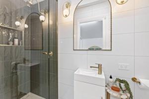 a bathroom with a shower and a sink and a mirror at • Cottage 1851 • Boutique in Brown Hill in Gong Gong