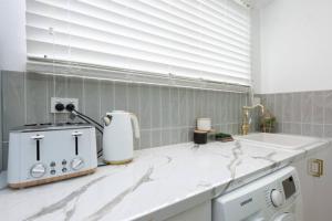 a kitchen with white marble counter tops and a sink at • Cottage 1851 • Boutique in Brown Hill in Gong Gong