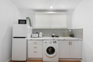a kitchen with a refrigerator and a washing machine at • Cottage 1851 • Boutique in Brown Hill in Gong Gong +13 photos