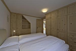una camera con un grande letto e armadi in legno di Chesa da la Posta - Silvaplana a Silvaplana