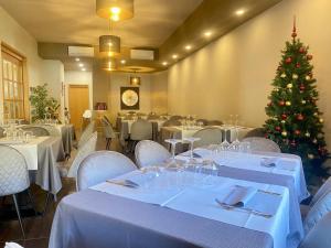 una sala da pranzo con tavoli e un albero di Natale di Albergo Stazione a Roveredo