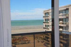a view of the beach from the balcony of a building at Duplex Penthouse Plaza in De Panne