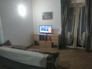 sala de estar con sofá y TV en CASCINA LEGNAGO trilocale a 6 chilometri da SALO', en Villanuova sul clisi