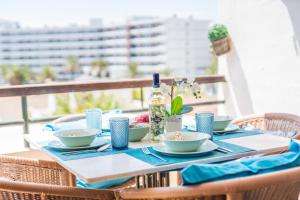a table with dishes and a bottle of wine at Ideal Property Mallorca - Mas i Reus 10 in Alcudia