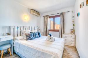 a bedroom with a bed and a desk and a window at Ideal Property Mallorca - Mas i Reus 10 in Alcudia