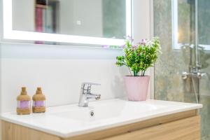 a bathroom sink with a vase of flowers on it at Ideal Property Mallorca - Mas i Reus 10 in Alcudia +19 photos