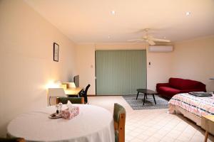 - un salon avec un lit et un canapé rouge dans l'établissement Spacious studio in AliceSprings QueenBed+KSAirbed, à Alice Springs