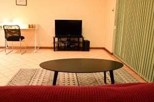 a living room with a coffee table and a tv at Spacious studio in AliceSprings QueenBed+KSAirbed in Alice Springs