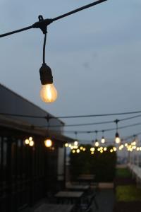 eine Reihe von Lichtern, die von einer Terrasse hängen in der Unterkunft Neo Hotel Puri Indah in Jakarta