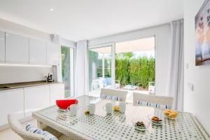 eine Küche und ein Esszimmer mit einem Glastisch und Stühlen in der Unterkunft Ideal Property Mallorca - Margalida in Alcúdia