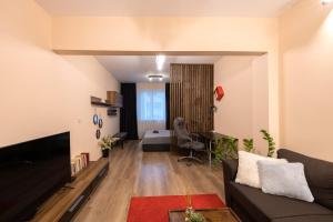 a living room with a couch and a bedroom at The Red Point in Varna City