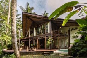 ein Haus im Dschungel mit einem großen Schlafzimmer in der Unterkunft Casa Pohon Ubud in Ubud
