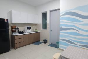 a kitchen with a refrigerator and a counter top at Cinema Blue Ocean 3 bedroom house kids water park in Shah Alam