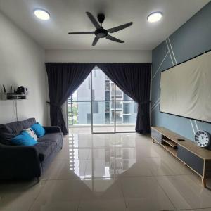 a living room with a couch and a flat screen tv at Cinema Blue Ocean 3 bedroom house kids water park in Shah Alam