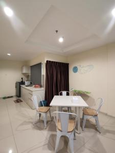 een keuken en een tafel en stoelen in een kamer bij Peaceful 1-bedroom unit at Marina Island by JoMy Homestay in Lumut