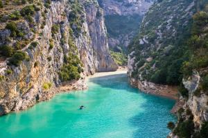 a boat in a river between two cliffs at Studio confortable au centre de Manosque in Manosque