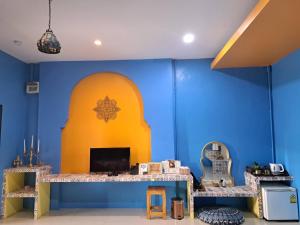 a room with a blue and yellow wall with a desk at The Sun resort Ratchaburi in Ratchaburi