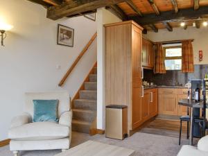 a living room with a staircase and a kitchen at Doddick Chase Cottage - Uk1363 in Threlkeld