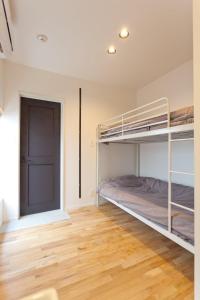 a bedroom with bunk beds and a wooden floor at CASA Kamakura Espresso&BED in Kamakura